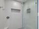 Modern shower featuring gray tile, glass door, and a built-in shelf at 2671 Clubhouse N Dr, Clearwater, FL 33761