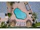 Aerial shot of a community pool, lounge seating, tiki umbrellas, and lush tropical landscaping at 2675 St Josephs E Dr # C, Dunedin, FL 34698