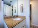 Bathroom featuring granite countertops and vanity with a large mirror at 2675 St Josephs E Dr # C, Dunedin, FL 34698
