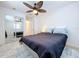 Bright bedroom featuring a ceiling fan, mirror closet and a king bed with blue and white pillows at 2675 St Josephs E Dr # C, Dunedin, FL 34698