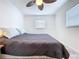 Bright bedroom featuring a ceiling fan and a king bed with blue and white pillows at 2675 St Josephs E Dr # C, Dunedin, FL 34698