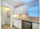 Kitchen featuring stainless dishwasher, granite countertop, tiled backsplash and stacked washer/dryer at 2675 St Josephs E Dr # C, Dunedin, FL 34698