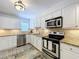 Well-lit kitchen with white cabinets, stainless steel appliances, and stylish backsplash at 2675 St Josephs E Dr # C, Dunedin, FL 34698