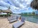 Pool deck features several lounge chairs, tiki umbrella table, waterfront and community views at 2675 St Josephs E Dr # C, Dunedin, FL 34698