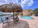 Community waterfront pool area, with lounge chairs, tiki umbrellas, and beautiful water views at 2675 St Josephs E Dr # C, Dunedin, FL 34698