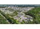 An aerial view of a neighborhood with houses near a pond surrounded by trees at 2821 Lytton Hall Dr, Zephyrhills, FL 33540