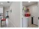 Bright laundry room with tile flooring, modern washer and dryer, and convenient shelving for storage at 2821 Lytton Hall Dr, Zephyrhills, FL 33540