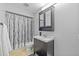 Bathroom featuring sink with mirror, toilet, and shower with white and gray patterned curtain at 305 Bryan Oak Ave, Brandon, FL 33511