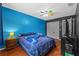 Bedroom with light hardwood floors, blue accent wall, gaming themed bedding, and a ceiling fan at 305 Bryan Oak Ave, Brandon, FL 33511