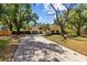 Inviting yellow home exterior with mature trees and a long driveway at 305 Bryan Oak Ave, Brandon, FL 33511