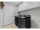 Functional laundry room with modern black washer and dryer and ample cabinet space at 305 Bryan Oak Ave, Brandon, FL 33511