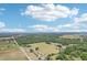Expansive aerial view showcasing the property's surrounding green landscapes, dotted with trees and scattered homes at 32860 Drake Estates Way, Dade City, FL 33525