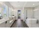 Open bathroom with double vanities, a soaking tub, and a walk-in shower for a luxurious bathing experience at 32860 Drake Estates Way, Dade City, FL 33525
