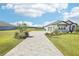 Long paved driveway leading to a well-maintained one-story home with a three-car garage at 32860 Drake Estates Way, Dade City, FL 33525