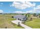 Stunning aerial view of a modern home with a paved driveway and a well-maintained, expansive green yard at 32860 Drake Estates Way, Dade City, FL 33525