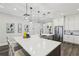 Bright kitchen with quartz counters, stainless steel appliances, pendant lighting, and dark wood floors at 32860 Drake Estates Way, Dade City, FL 33525