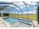 The screened pool and spa offer picturesque views of the surrounding green space and blue skies at 32860 Drake Estates Way, Dade City, FL 33525