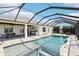 Screened pool area boasts a built-in spa, outdoor kitchen, and covered patio with ample space for dining and lounging at 32860 Drake Estates Way, Dade City, FL 33525