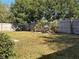 Backyard features a rockery with palm trees with lush lawn and a wooden fence for privacy at 3414 Berry Blossom Ln, Plant City, FL 33567
