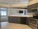 The kitchen showcases stainless steel appliances, tile floors, white countertops, and gray cabinetry at 3414 Berry Blossom Ln, Plant City, FL 33567