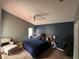 Comfortable main bedroom featuring a ceiling fan, neutral carpet, and a cozy armchair and ottoman set at 3414 Berry Blossom Ln, Plant City, FL 33567
