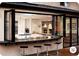 Indoor/outdoor kitchen with bar overlooking the living room featuring a fireplace at 3420 Channelside Ct, Safety Harbor, FL 34695