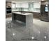 Modern kitchen features an island and stainless steel appliances with marble floor at 3420 Channelside Ct, Safety Harbor, FL 34695