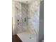 Modern shower showcasing sleek, light-colored marble tiling and a recessed shelving niche at 3420 Channelside Ct, Safety Harbor, FL 34695
