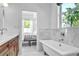 Elegant bathroom featuring a marble bathtub, white marble wall, and window view at 349 Belleair Ne Dr, St Petersburg, FL 33704