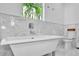 Elegant bathroom featuring a modern bathtub, marble accents, and a bright window view at 349 Belleair Ne Dr, St Petersburg, FL 33704