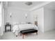 Bright bedroom featuring white walls, an elegant bed with bench, and stylish lighting fixture at 349 Belleair Ne Dr, St Petersburg, FL 33704