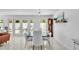 Open-concept dining room with modern chandelier, sleek table, chairs, and french doors leading to a patio at 349 Belleair Ne Dr, St Petersburg, FL 33704