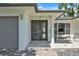 Inviting entryway featuring a modern front door, stylish sidelight, and a charming outdoor seating area at 349 Belleair Ne Dr, St Petersburg, FL 33704