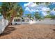 Exterior backyard view showcasing the home with a large mulched area and a white fence at 3512 Haines N Rd, St Petersburg, FL 33704