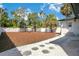 Large backyard featuring mulch, stepping stones and a white fence for privacy at 3512 Haines N Rd, St Petersburg, FL 33704