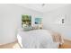 Bright bedroom featuring light wood floors, a plush comforter, and a large window that fills the room with natural light at 3512 Haines N Rd, St Petersburg, FL 33704