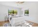Bright bedroom with neutral decor, a large window, ceiling fan, and light wood flooring, creating a cozy retreat at 3512 Haines N Rd, St Petersburg, FL 33704