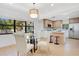 Open concept dining and kitchen area with modern lighting and appliances, and light wood flooring throughout at 3512 Haines N Rd, St Petersburg, FL 33704