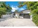Charming home exterior featuring a white facade, dark garage door, and well-maintained landscaping at 3512 Haines N Rd, St Petersburg, FL 33704