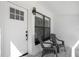 Cozy front porch featuring two chairs, patterned tile, and a bright white door with a grid window at 3512 Haines N Rd, St Petersburg, FL 33704