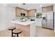 Bright kitchen with stainless steel appliances, light wood cabinets, and a kitchen island with stool seating at 3512 Haines N Rd, St Petersburg, FL 33704