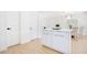 Bright kitchen featuring a white island with gold hardware, hardwood floors and views of dining space at 3512 Haines N Rd, St Petersburg, FL 33704