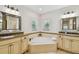 Bathroom with a tub, dual sinks, granite countertops, and decorative mirrors in a bright space at 3710 W San Pedro St, Tampa, FL 33629