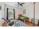 Cozy bedroom with hardwood floors, ceiling fan, and a comfortable chair beside a sunny window at 3710 W San Pedro St, Tampa, FL 33629