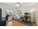 Multi-purpose bedroom with a twin bed, workspace, ceiling fan, and a hardwood floor at 3710 W San Pedro St, Tampa, FL 33629