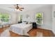 Bright bedroom boasts hardwood floors, ceiling fan, and natural light from windows with tree views at 3710 W San Pedro St, Tampa, FL 33629