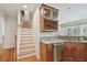 Kitchen area featuring wooden cabinets, granite countertops, stainless steel appliances, and staircase access at 3710 W San Pedro St, Tampa, FL 33629