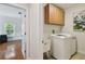 Convenient laundry room with overhead cabinets, utility sink, and modern washing machine at 3710 W San Pedro St, Tampa, FL 33629