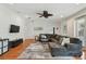 Comfortable living room with sectional sofa, wood floors, ceiling fan, and large windows at 3710 W San Pedro St, Tampa, FL 33629
