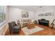 Cozy living room with hardwood floors, large windows, neutral decor, and an accent rug at 3710 W San Pedro St, Tampa, FL 33629